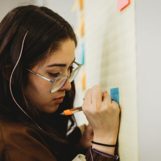 Youth participant writes notes on flip chart