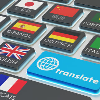 Macro view of computer keyboard with national flags of world countries on keys and blue translate button