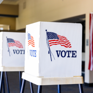 Three voting booths adorned with US flags