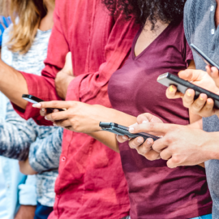 A line of young people looking at cell phones