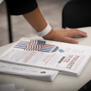 Printed flyers promoting voting stacked on a table