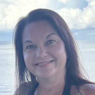 A smiling woman posing outdoors