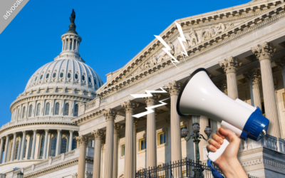 A hand holding a megaphone with US Capitol in the background