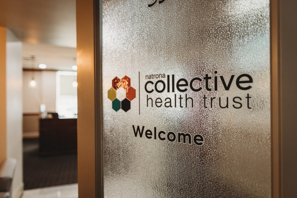 A door with the logo for Natrona Collective Health Trust on frosted glass.