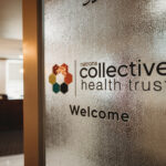 A door with the logo for Natrona Collective Health Trust on frosted glass.