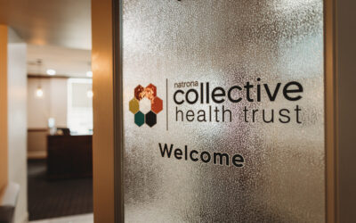 A door with the logo for Natrona Collective Health Trust on frosted glass.