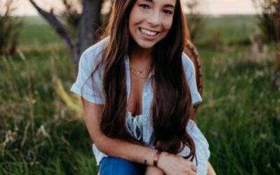 A young woman with long dark hair posing in the sunset