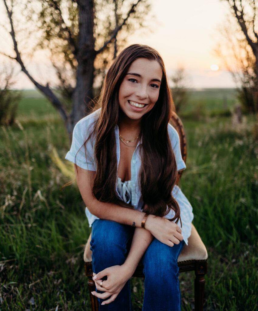 A young woman with long dark hair posing in the sunset