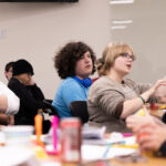 A group of youth gathered at tables for discussion