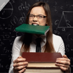 Portrait of woman grimacing while holding book in her mouth and stack of books in her hands