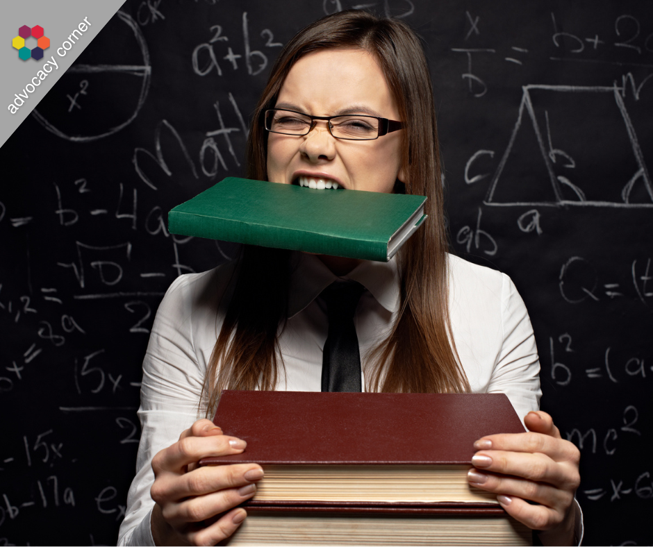 Portrait of woman grimacing while holding book in her mouth and stack of books in her hands