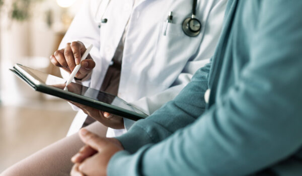 Doctor, hands and tablet with patient for consultation, medical advice or procedure at clinic. Closeup, healthcare employee and client with technology for health appointment or checklist at hospital
