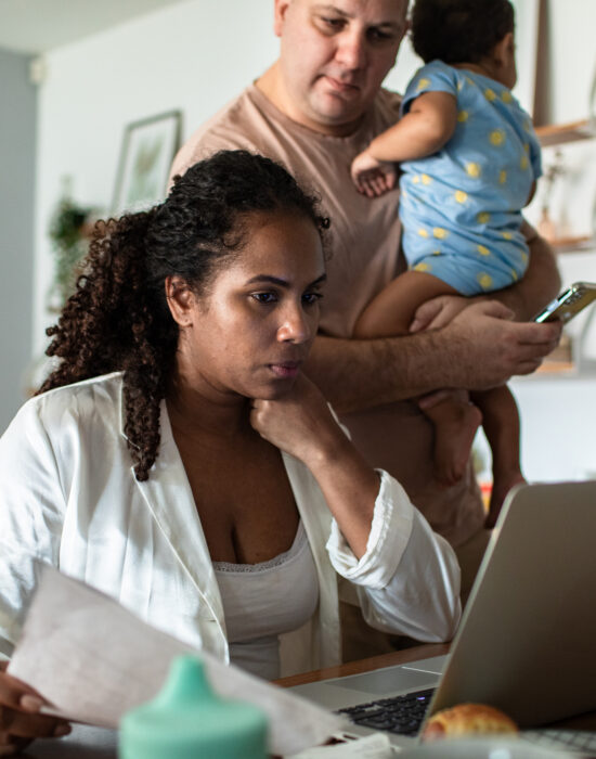 Close up of a Young family having breakfast and going over their bills and home finances on the laptop