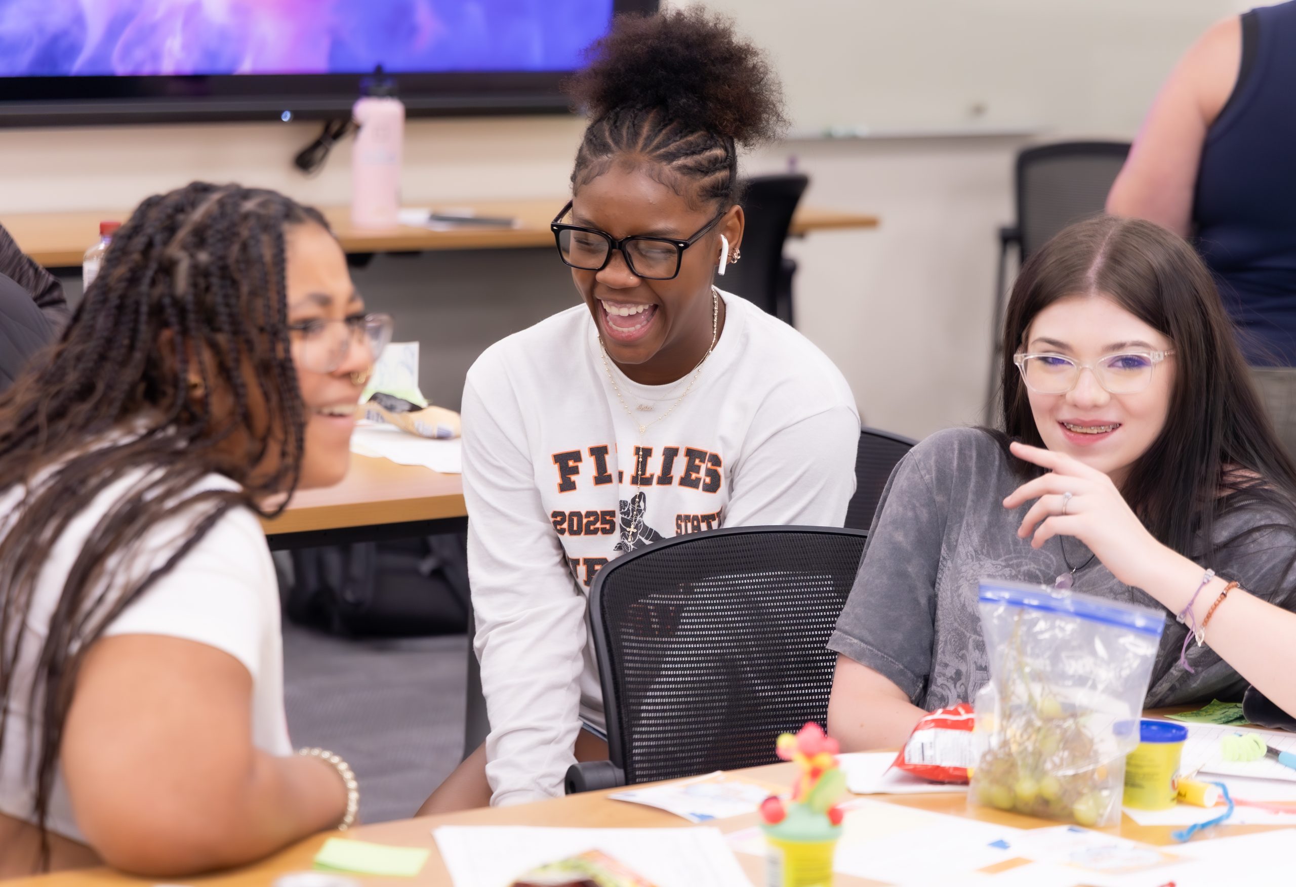 Three teens laughing together during Youth Takeover Week