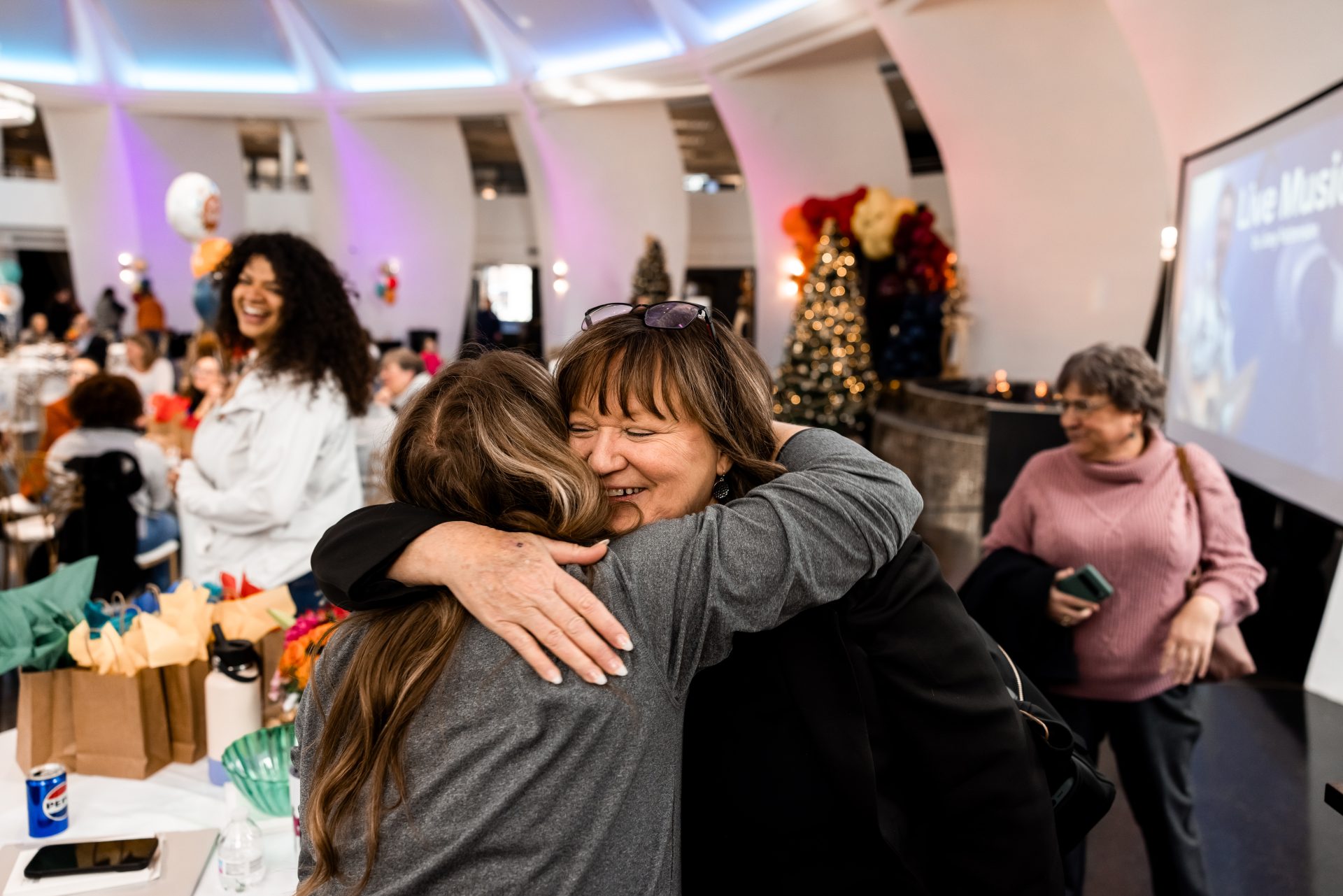 Two guests hugging beside the giveaway table