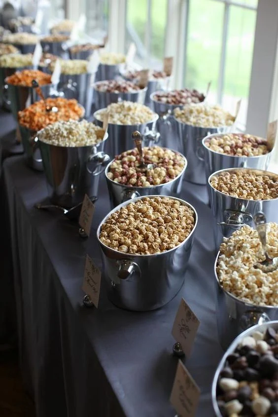 A popcorn bar with buckets of flavored popcorn
